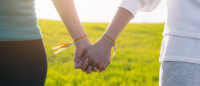 Close up of two women holding hands.